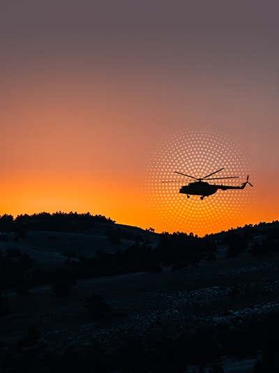 helicopter flying over a hill
