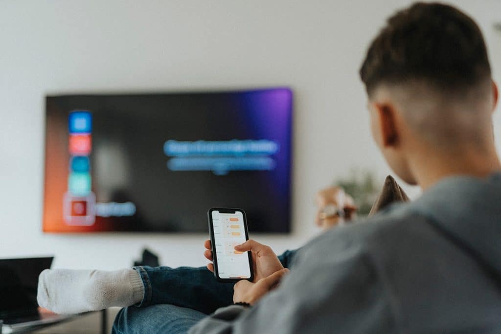man controlling free-to-air TV with phone app