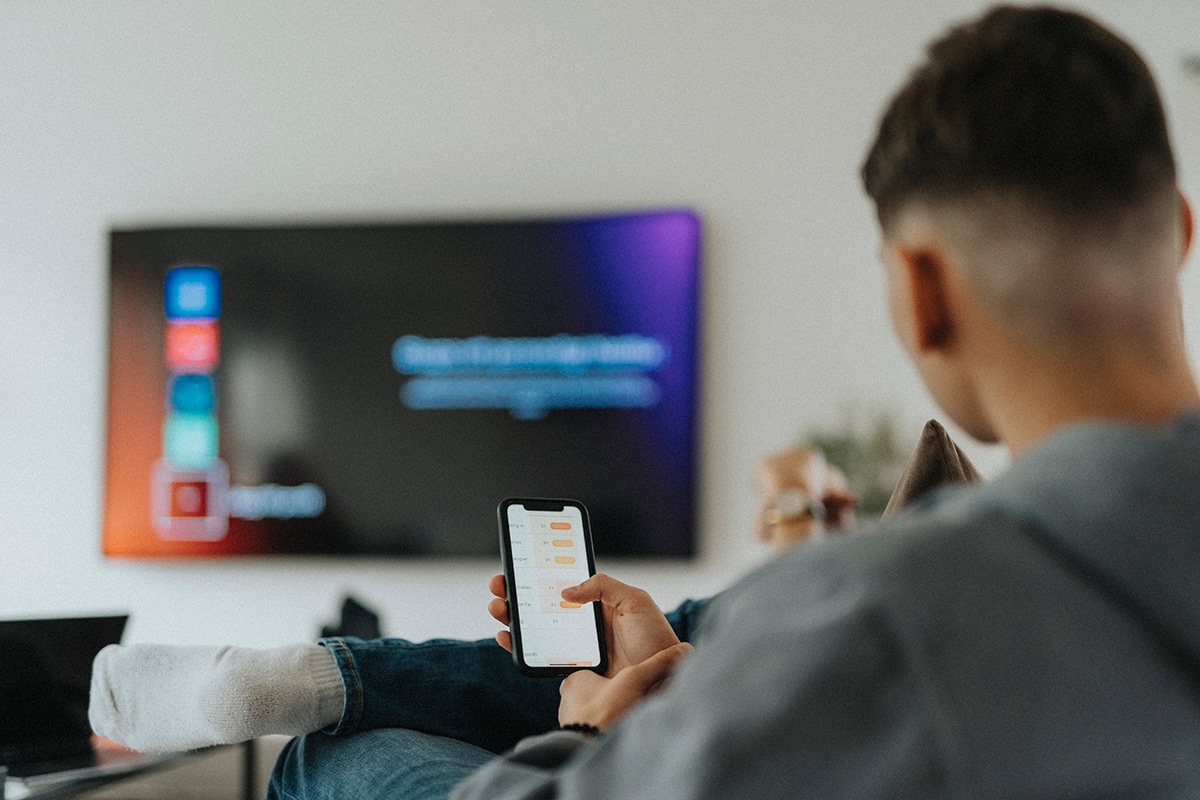 man controlling free-to-air TV with phone app