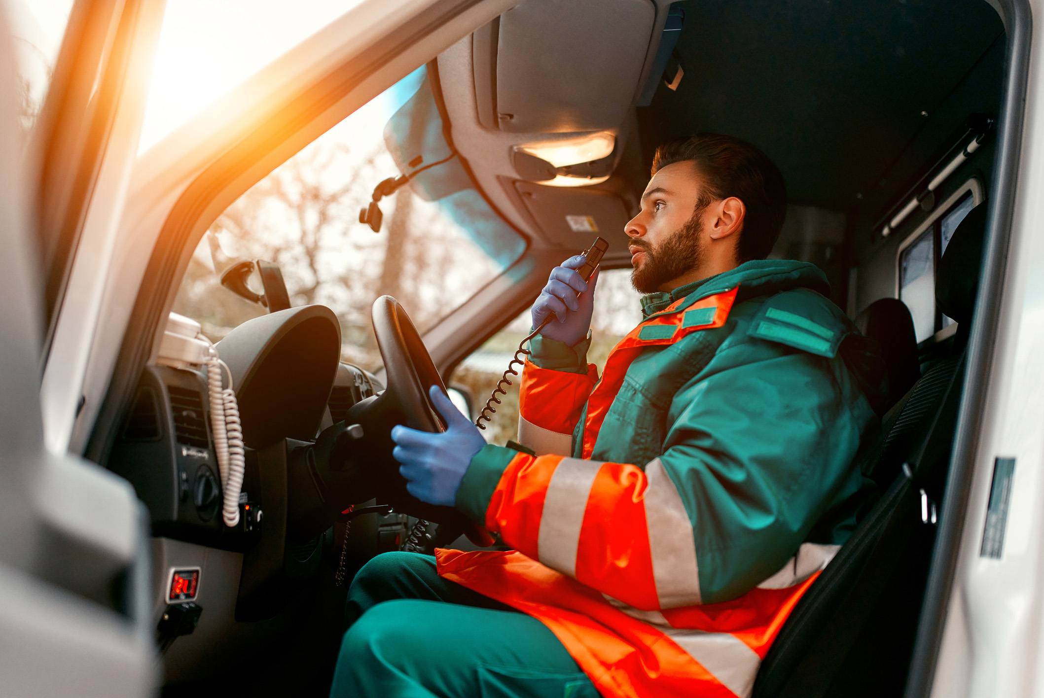 Emergency responder using radio in vehicle, ensuring real-time communication during critical operations.