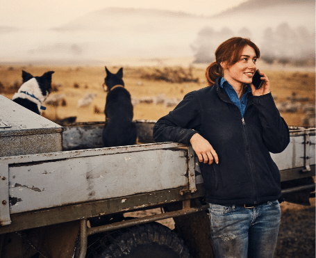 Woman using a cell phone outdoors, symbolizing collaboration between mobile network operators.